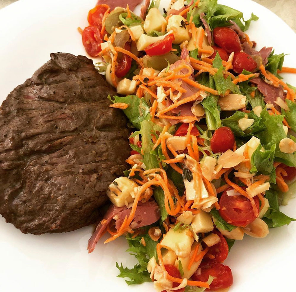 Prato com carne e uma salada que representa o tipo de de alimentação que pode contribuir para uma imunidade alta.