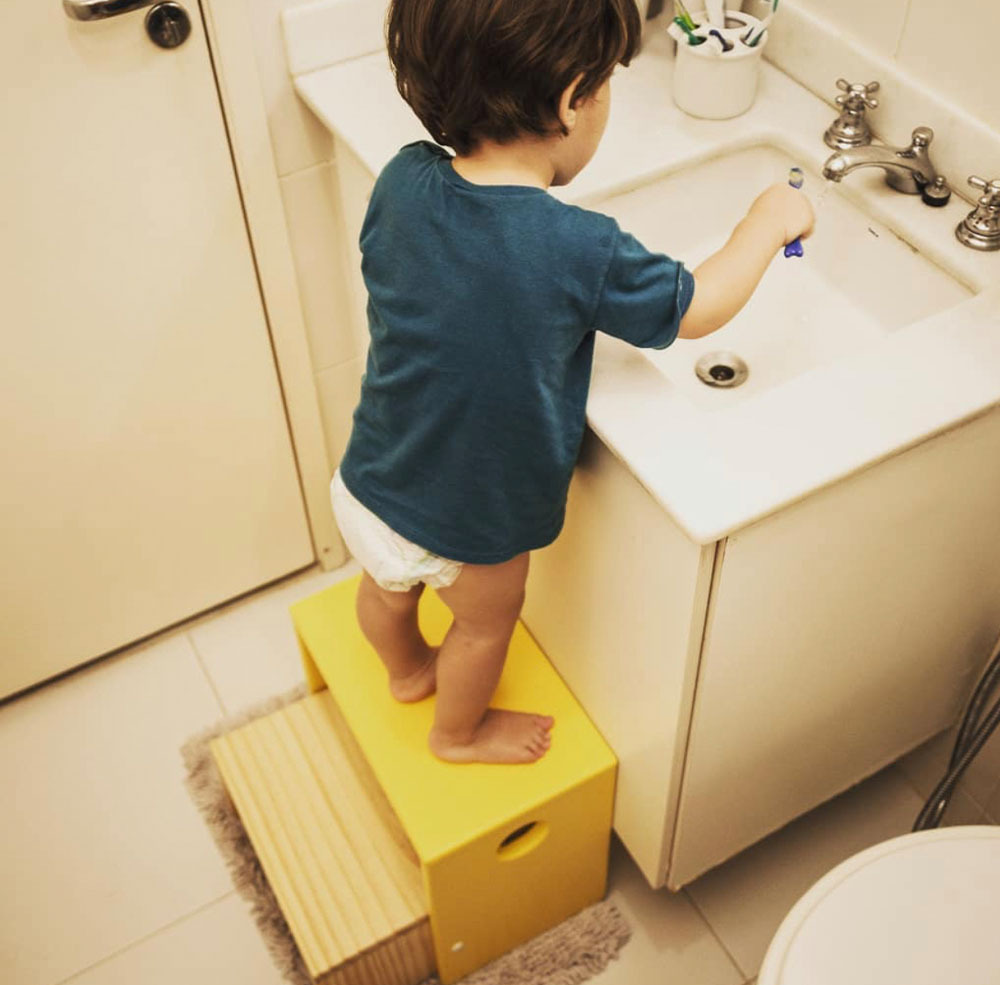 Criança usando pia com método montessori