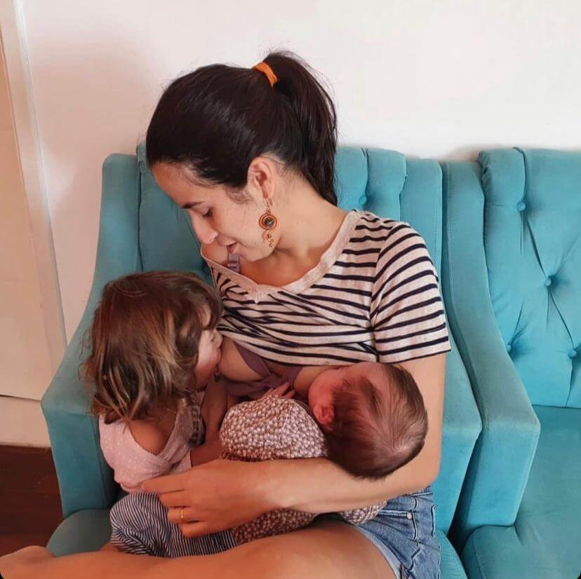 Dra. Jannuzzi fazendo a amamentação de suas duas filhas, seguindo com o aleitamento materno prolongado.