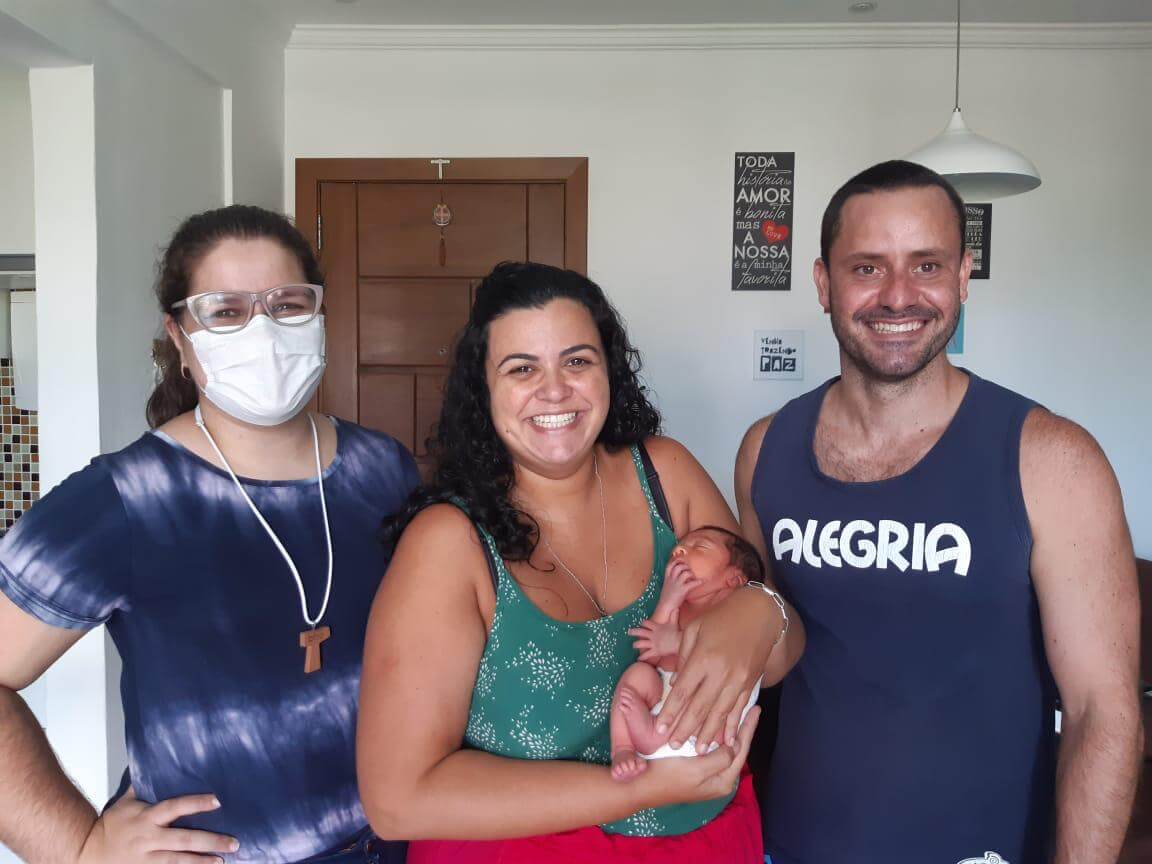 À esquerda está a consultora de amamentação Suellen Reis e ao lado dela os clientes que são a mãe do bebê, o bebê e o pai da criança. 