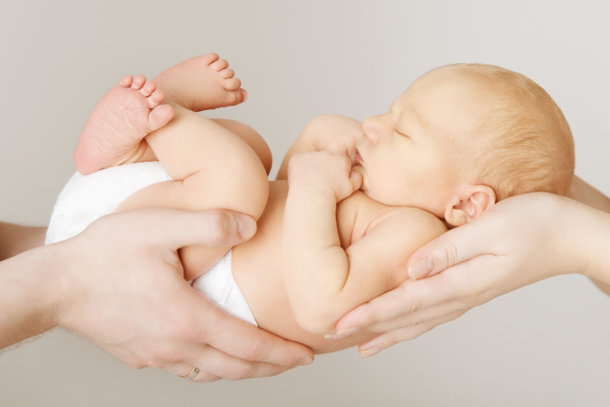 Estratégia Cocoon - Bebê sendo carregado por duas mãos